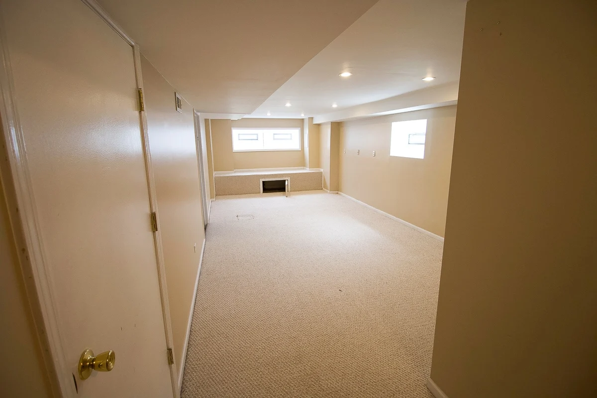 Same basement after Cakewalk Restore — fully restored, clean carpet, bright finish